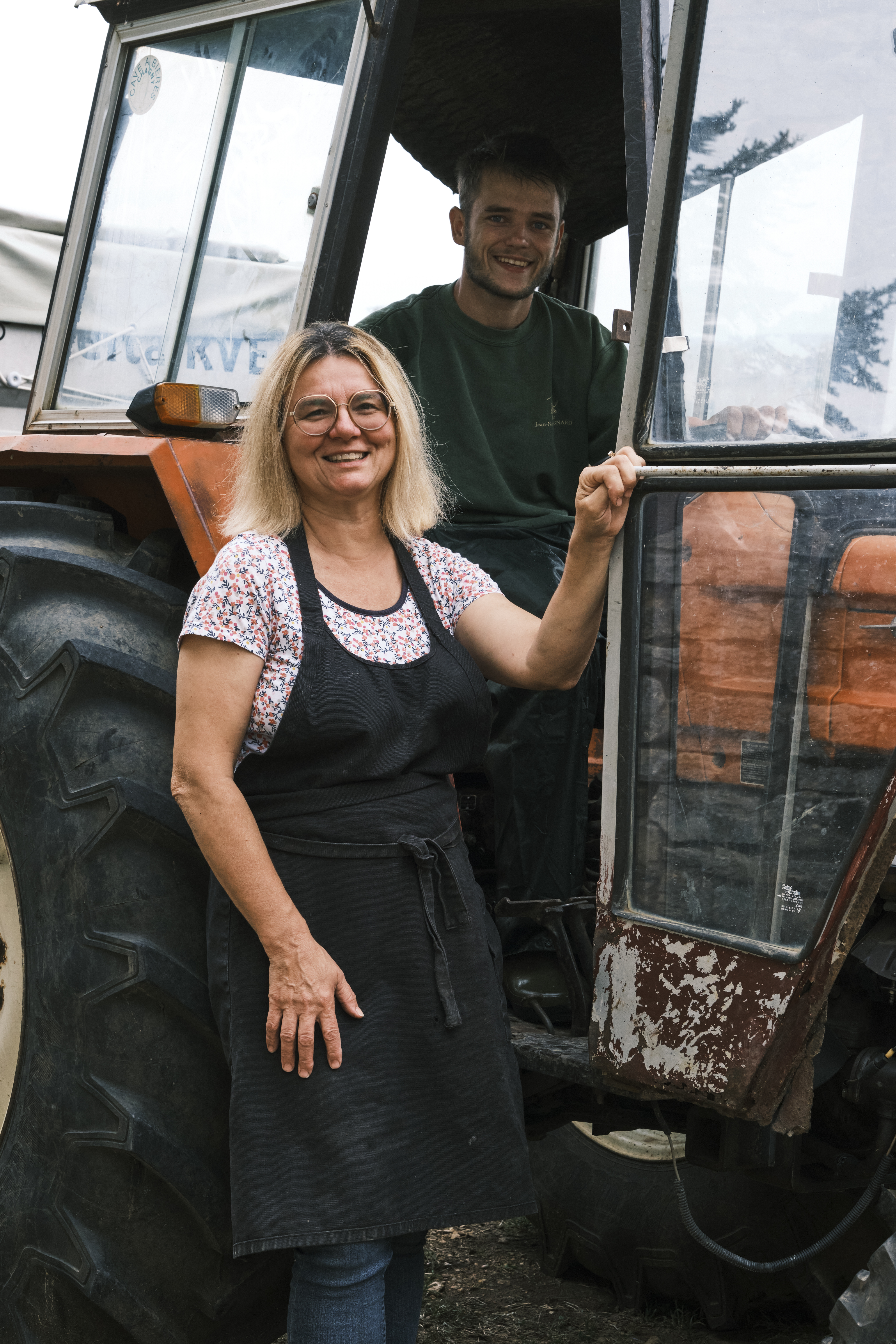 Mother-and-son Caroline Lestimé and Philippe Lestimé stand in front of a tractor.
